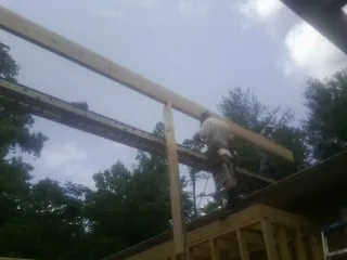 Carpenter setting a ridge beam over a new addition frame — Ice Dam Removal by Roofing Brothers in Eagle Creek