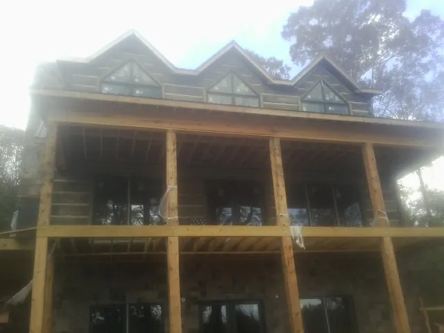 Dormers and porch framing on a large log home under construction — Roof Coating work by our crew in Eagle Creek