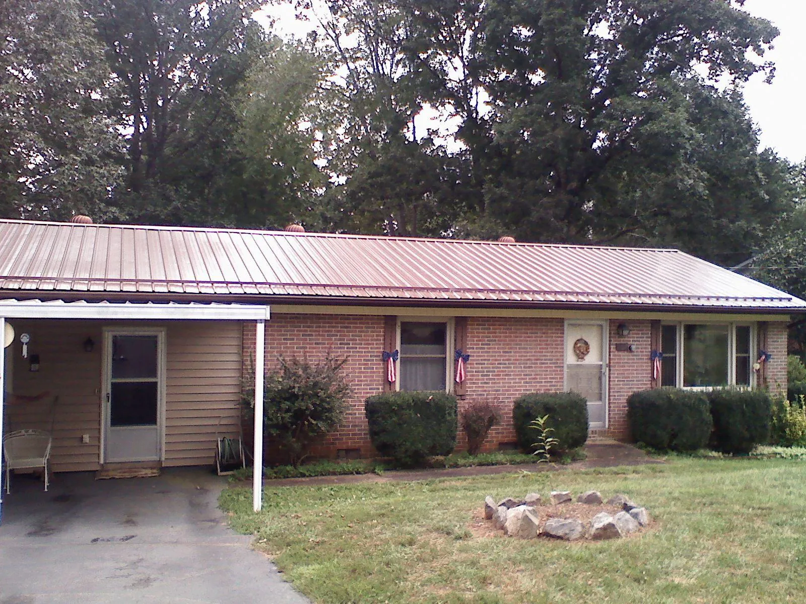 Bronze metal roof and carport on a brick ranch home — Roof Repair work by our crew in Eagle Creek
